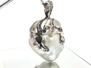 Natural blue south sea pearl with 18k white gold , rhodium and white / black diamonds .