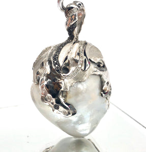 Natural blue south sea pearl with 18k white gold , rhodium and white / black diamonds .
